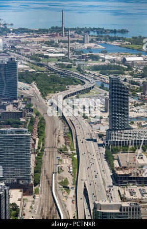 Toronto, Ontario, Kanada. Blick nach Osten von der Oberseite der CN Tower entlang Gardiner Expressway Richtung Häfen am Lake Ontario im Sommer, vertikale Ausrichtung. Stockfoto