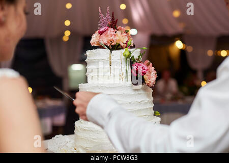 Braut und Bräutigam auf Hochzeit anschneiden der Hochzeitstorte Stockfoto