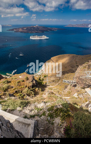 Wunderschöner Blick über die Ägäis von Fira auf Santorini, Griechenland. Kreuzfahrt Schiffe, Boote und die Caldera können im tiefen blauen Meer gesehen werden. Stockfoto