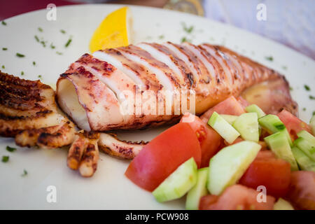 Nahaufnahme des leckeren gegrillten Calamari und Gemüse Griechischer Salat, frisch in Santorini, Griechenland Stockfoto