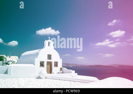 Weiße orthodoxe Kirche Glockenturm. Oia, Santorini, Griechenland. Copyspace. Farbiges Licht Undichtigkeit Filter angewendet. Stockfoto