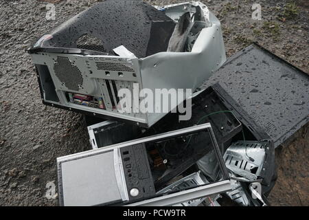 Begriff der Freiheit von der Computersucht - Mann bricht das Gerät von einem Computer mit einem Hummer außerhalb, See mit Wald Hintergrund. Zornigen Mann zerstören ein Laptop oder Computer mit einem Hammer. Stockfoto