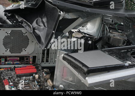 Begriff der Freiheit von der Computersucht - Mann bricht das Gerät von einem Computer mit einem Hummer außerhalb, See mit Wald Hintergrund. Zornigen Mann zerstören ein Laptop oder Computer mit einem Hammer. Stockfoto