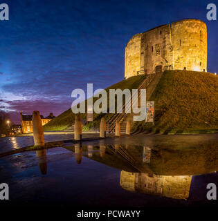 York Castle oder Cliffords Tower als sonst bekannt. Nach Sonnenuntergang in der Dämmerung mit einer Reflexion in einer Pfütze. Stockfoto