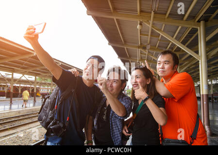 Selfie Gruppe von vier Freunde mit einem Smart Phone in einem Bahnhof im Sommer Stockfoto