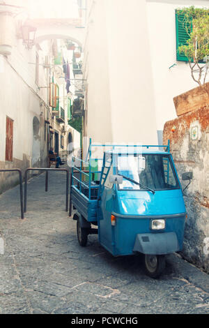 Kreuz - verarbeitete Bild des alten blauen Italienischen dreirädrigen Auto auf sonnigen Abend auf schmalen Straße geparkt in der kleinen Stadt von Vietri Sul Mare an der Amalfi Küste, Stockfoto