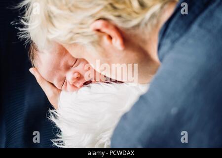 Mutter vorsichtig Holding ihr neugeborenes Baby boy in flauschige Decke Stockfoto