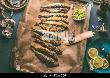 Gegrillte Sardinen auf Backblech mit Zutaten: Zitrone, Knoblauch und Kräuter für leckere Meeresfrüchte essen. Kochen Vorbereitung der Fische Stockfoto