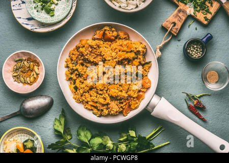 Gesunde vegetarische Couscous mit Zutaten: Gemüse, Kräuter auf dunklem Hintergrund, Ansicht von oben, flach. Stockfoto