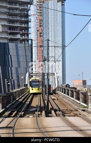 Eine Ansicht eines MetroLink Tram im Stadtzentrum von Manchester, moderne Gebäude im Bau im Hintergrund. Mai 2018 Stockfoto