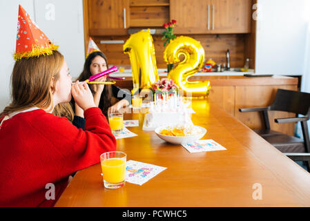 Gruppe Kinder feiern Geburtstag zusammen und bläst in die Pfeifen Stockfoto