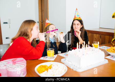 Gruppe Kinder feiern Geburtstag zusammen und bläst in die Pfeifen Stockfoto