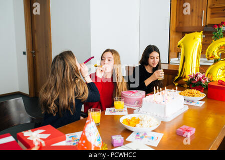Gruppe Kinder feiern Geburtstag zusammen und bläst in die Pfeifen Stockfoto