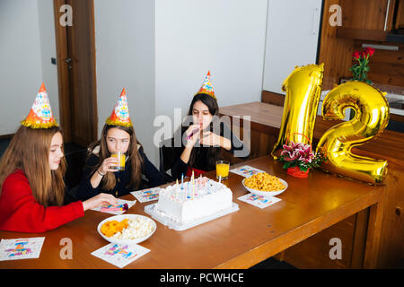 Gruppe Kinder feiern Geburtstag zusammen und bläst in die Pfeifen Stockfoto