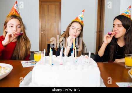 Gruppe Kinder feiern Geburtstag zusammen und bläst in die Pfeifen Stockfoto