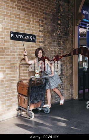 Die Leute, die Fotos von 9 3/4 Plattform im Bahnhof King's Cross, London, Station, wo die Schüler von Hogwarts Schule Fang den Hogwarts Express. Stockfoto