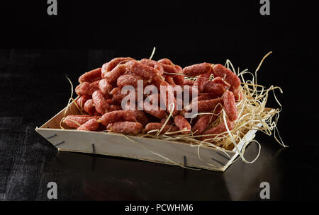 Picknick salami Wurst in Holzkiste auf schwarzem Hintergrund Stockfoto