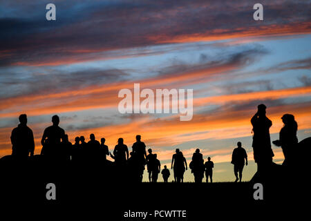 Festivalbesucher Kopf heraus bei Sonnenuntergang auf dem Campingplatz bei Bestival am Lulworth Immobilien in Dorset. Stockfoto