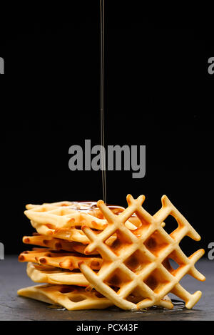 Foto von Wiener Wafer mit Honig auf einem schwarzen Hintergrund Stockfoto