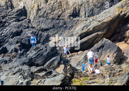 North Wales, Großbritannien Wetter: Warme, sonnige Wetter kehrt in vielen Teilen der britischen dieses Wochenende, wie diese Leute entdeckt rock Bündelung auf der Küstenlinie am Cable Bay, Anglesey, Nordwales Stockfoto