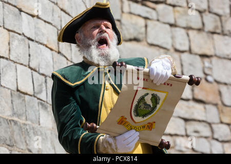 Windsor, Großbritannien. 4. August 2018. Mike Andrew, Stadtausrufer von Ferndown, beteiligt sich an der Antike und ehrenvolle Gilde Town Criers (AHGTC) nationalen Meisterschaft unter den Mauern von Schloss Windsor. 40 Town criers aus ganz Großbritannien und zwei aus Australien konkurrieren in zwei Runden von Weinen, die ersten, die ein Home Schrei auf Diktion, den Tonfall, die Klarheit und die Lautstärke und die zweite ein Schrei auf das Thema 'Feier' gezählt. Credit: Mark Kerrison/Alamy leben Nachrichten Stockfoto