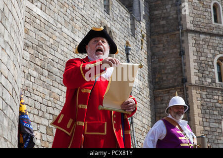 Windsor, Großbritannien. 4. August 2018. Mike Billingham, Stadtausrufer des Medway Towns, macht eine Ansage vor vierzig Town criers aus ganz Großbritannien und zwei aus Australien nehmen Sie Teil an den Alten und ehrenvolle Gilde Town Criers (AHGTC) nationalen Meisterschaft unter den Mauern von Schloss Windsor. Jede stadtausrufer konkurriert in zwei Runden von Weinen, die ersten, die ein Home Schrei auf Diktion, den Tonfall, die Klarheit und die Lautstärke und die zweite ein Schrei auf das Thema 'Feier' gezählt. Credit: Mark Kerrison/Alamy leben Nachrichten Stockfoto