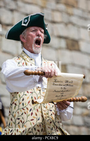 Windsor, Großbritannien. 4. August 2018. Kevin Ward, Stadtausrufer von Bromsgrove, beteiligt sich an der Antike und ehrenvolle Gilde Town Criers (AHGTC) nationalen Meisterschaft unter den Mauern von Schloss Windsor. 40 Town criers aus ganz Großbritannien und zwei aus Australien konkurrieren in zwei Runden von Weinen, die ersten, die ein Home Schrei auf Diktion, den Tonfall, die Klarheit und die Lautstärke und die zweite ein Schrei auf das Thema 'Feier' gezählt. Credit: Mark Kerrison/Alamy leben Nachrichten Stockfoto