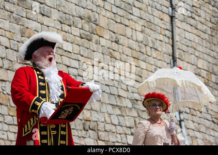 Windsor, Großbritannien. 4. August 2018. Trevor Heeks, Stadtausrufer von Trowbridge, nimmt teil an der Alten und ehrenvolle Gilde Town Criers (AHGTC) nationalen Meisterschaft unter den Mauern von Schloss Windsor. 40 Town criers aus ganz Großbritannien und zwei aus Australien konkurrieren in zwei Runden von Weinen, die ersten, die ein Home Schrei auf Diktion, den Tonfall, die Klarheit und die Lautstärke und die zweite ein Schrei auf das Thema 'Feier' gezählt. Credit: Mark Kerrison/Alamy leben Nachrichten Stockfoto