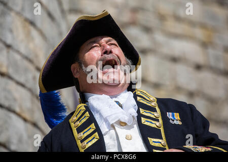 Windsor, Großbritannien. 4. August 2018. Les Ellis, Stadtausrufer von Dartmouth, beteiligt sich an der Antike und ehrenvolle Gilde Town Criers (AHGTC) nationalen Meisterschaft unter den Mauern von Schloss Windsor. 40 Town criers aus ganz Großbritannien und zwei aus Australien konkurrieren in zwei Runden von Weinen, die ersten, die ein Home Schrei auf Diktion, den Tonfall, die Klarheit und die Lautstärke und die zweite ein Schrei auf das Thema 'Feier' gezählt. Credit: Mark Kerrison/Alamy leben Nachrichten Stockfoto