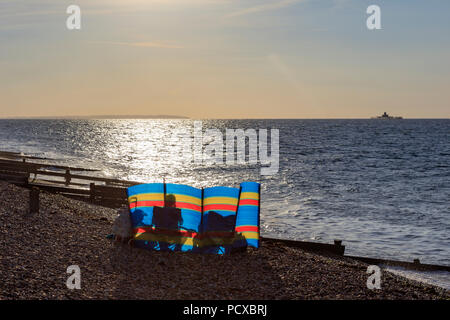 Herne Bay, Kent, Großbritannien. August 4 2018. UK Wetter. Nach einem Tag bewölkt, aber warm, der Wind nimmt wie die Sonne beginnt an der Themsemündung Nord Küste von Kent zu setzen. Die Menschen nutzen die Clearing cloud Picknicks am Strand, Spaziergänge und Sitzen nur im Sonnenlicht. Richard Donovan/Alamy leben Nachrichten Stockfoto