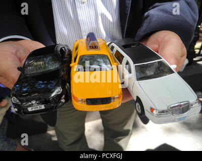 New York, USA. Juli 31, 2018. Hector Figueroa, Präsident der New York union Lokale 32 BJ, hält Spielzeugautos in seinen Händen, einschließlich einer klassischen gelben Taxi, namens Yellow Cab. (Dpa Bericht uber, überall: New York fürchtet um seine gelbe Taxis 05.08.2018) Credit: Johannes Schmitt-Tegge/dpa/Alamy leben Nachrichten Stockfoto