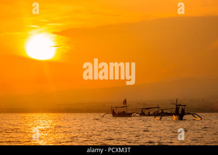 Indonesien. Sonnenaufgang auf dem Meer vor der Küste von Bali. Boote Warten auf das Aussehen der Delphine Stockfoto