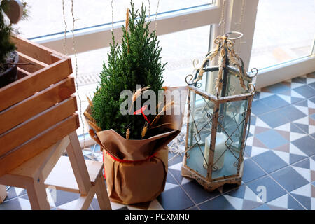 Weihnachten kleine Tanne mit dekorativen Laterne Lampe auf den Boden. Weihnachtsdekoration. Stockfoto