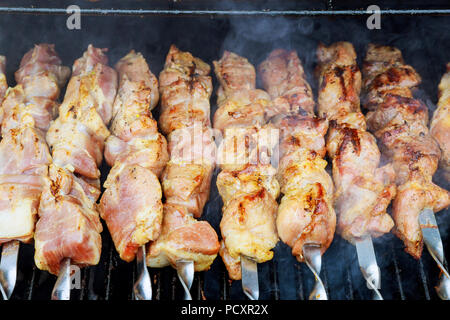 Saftige Scheiben von Fleisch mit Vorbereitung auf Feuer Shish Kebab am Spieß gekocht, im Freien Stockfoto