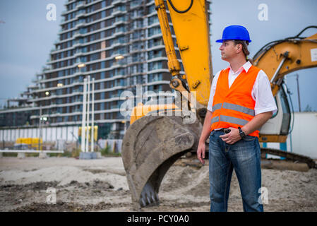 Ingenieur vor der Bagger auf der Baustelle Stockfoto