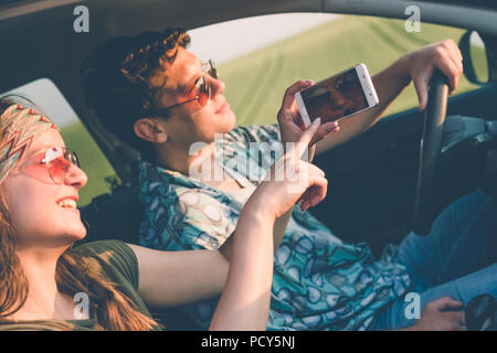 Junge moderne Paar fahren in die Natur und Sie ihr Smartphone. Stockfoto