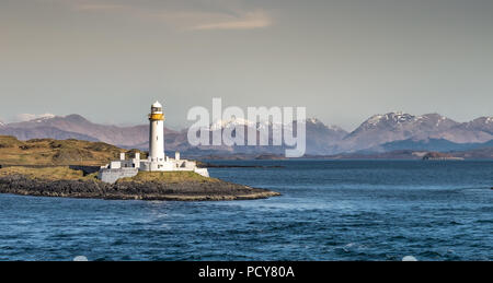 Blick auf den alten Eilean Musdile Leuchtturm in Schottland Highland, mit schneebedeckten Gipfeln im Hintergrund, Donnerstag, 12. April 2018, Schottland Stockfoto