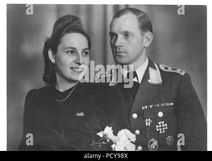 Oberfeldwebel Otto Thomas von 3. Kompanie, Fallschirmjäger-Regiment 2 und seine Frau Else posieren für die Kamera am Tag ihrer Hochzeit im Dezember 1942. Otto Thomas trägt die Farbbänder für: das Eiserne Kreuz 2.Klasse; Lange Service Medal IV Klasse; Osten Medaille; März 13 Gedenkmedaille 1938; 1. Oktober Gedenkmedaille 1938 mit Prager Burg Bar. Auf seiner Brust Otto Thomas trägt die Italienische Croce Al Valor Militare (Cross für militärische Tapferkeit) mit Galanterie Schwert auf der Multifunktionsleiste, Eisernes Kreuz 1.Klasse; Armee Fallschirmjäger Award Abzeichen; Wunde Abzeichen in Schwarz. Stockfoto