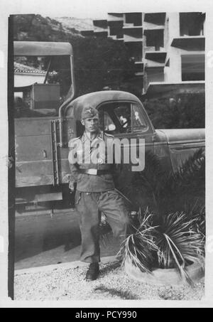 Feldwebel Otto Thomas von 3. Kompanie, Fallschirmjäger-Regiment 2, dargestellt im Sommer 1940, steht vor einem Lkw, die zu seiner Einheit. Er trägt seine Eisernen Kreuz 1.Klasse, Luftwaffe Fallschirmjäger Award Abzeichen, schwarze Wunde Abzeichen und Farbband auf das Eiserne Kreuz 2.Klasse. Am kleid Gelegenheiten, Thomas trug seine ursprüngliche Armee Fallschirmjäger Abzeichen und es scheint, er trug die Luftwaffe Version für den täglichen Gebrauch. Stockfoto