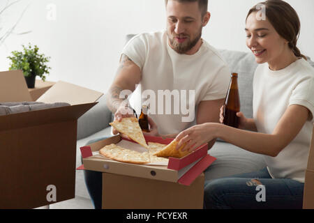 Glückliches Paar essen Pizza feiert Housewarming Party Stockfoto