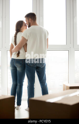 Glückliches Paar Küssen in der Nähe von Fenster über das Verschieben von t begeistert Stockfoto