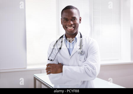 Portrait der junge lächelnde Arzt mit Stethoskop um den Hals, in der Klinik Stockfoto