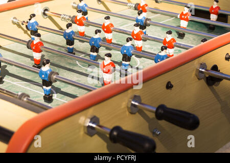 Nahaufnahme von Tischfußball (Kicker) mit Spielern in den Farben rot und blau Shirts. Stockfoto