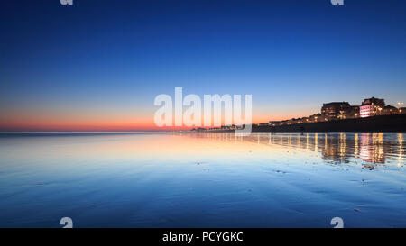 Sonnenuntergang Reflexionen auf dem Sand bei Sonnenuntergang, während der Ebbe in Brighton Stockfoto