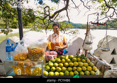 KANDY, SRI LANKA - Dez 28,2016: Junge Frau verkauft Mango auf einer Straße Hengst in Kandy am 28.Dezember 2016. Sri Lanka. Stockfoto