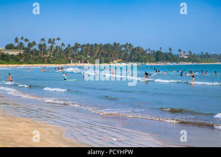 WELIGAMA SRI LANKA - Jan 5, 2017: unbekannter Mann Surfen auf einer kleinen Welle auf Weligama Beach am Jan 5, 2017. Sri Lanka. Es Küste des Indischen Ozeans ist. Stockfoto