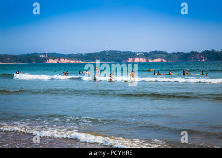 WELIGAMA SRI LANKA - Jan 5, 2017: unbekannter Mann Surfen auf einer kleinen Welle auf Weligama Beach am Jan 5, 2017. Sri Lanka. Es Küste des Indischen Ozeans ist. Stockfoto