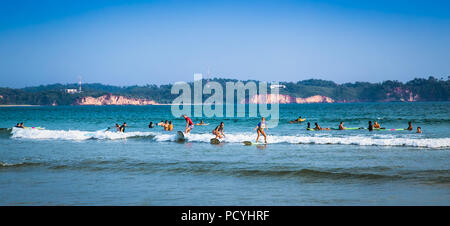 WELIGAMA SRI LANKA - Jan 5, 2017: unbekannter Mann Surfen auf einer kleinen Welle auf Weligama Beach am Jan 5, 2017. Sri Lanka. Es Küste des Indischen Ozeans ist. Stockfoto