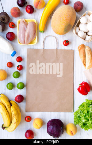 Shopping Konzept. Festlegen verschiedener Lebensmittel mit papiertüte auf weißem Holz- Tabelle, Ansicht von oben. Kochen Hintergrund. Flach von frischen Lebensmitteln. Overhead, Stockfoto