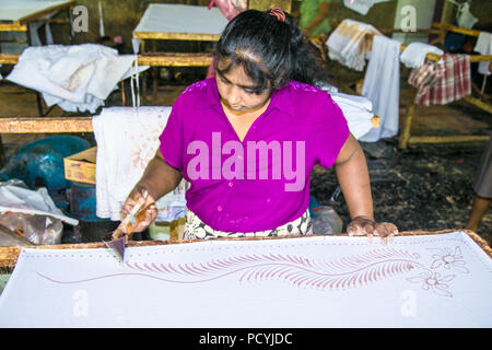 WELIGAMA, SRI LANKA - Jan 7, 2017: Alte Frau bei der Herstellung von Batik in Weligama auf Jan 7, 2017. Sri Lanka. Stockfoto